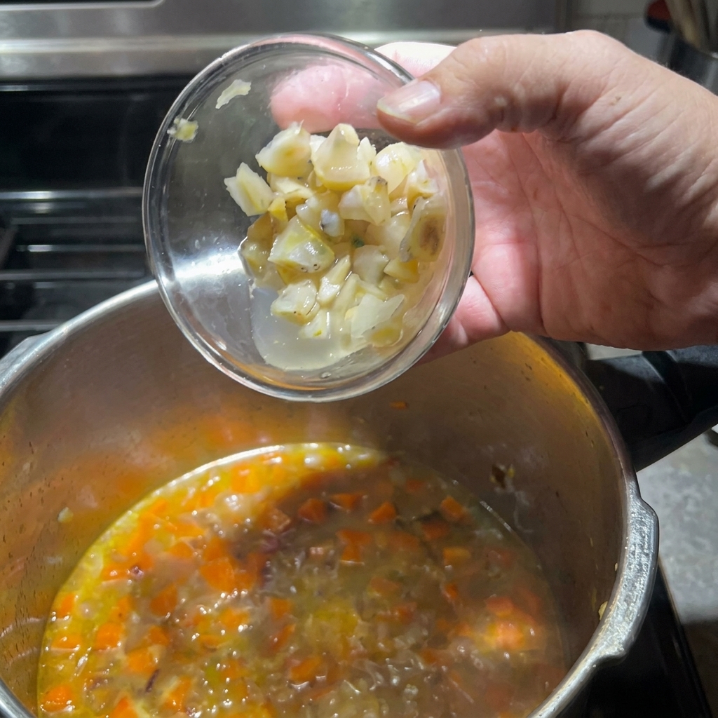 Ajout des morceaux de palourdes préparés dans la casserole avec les légumes.