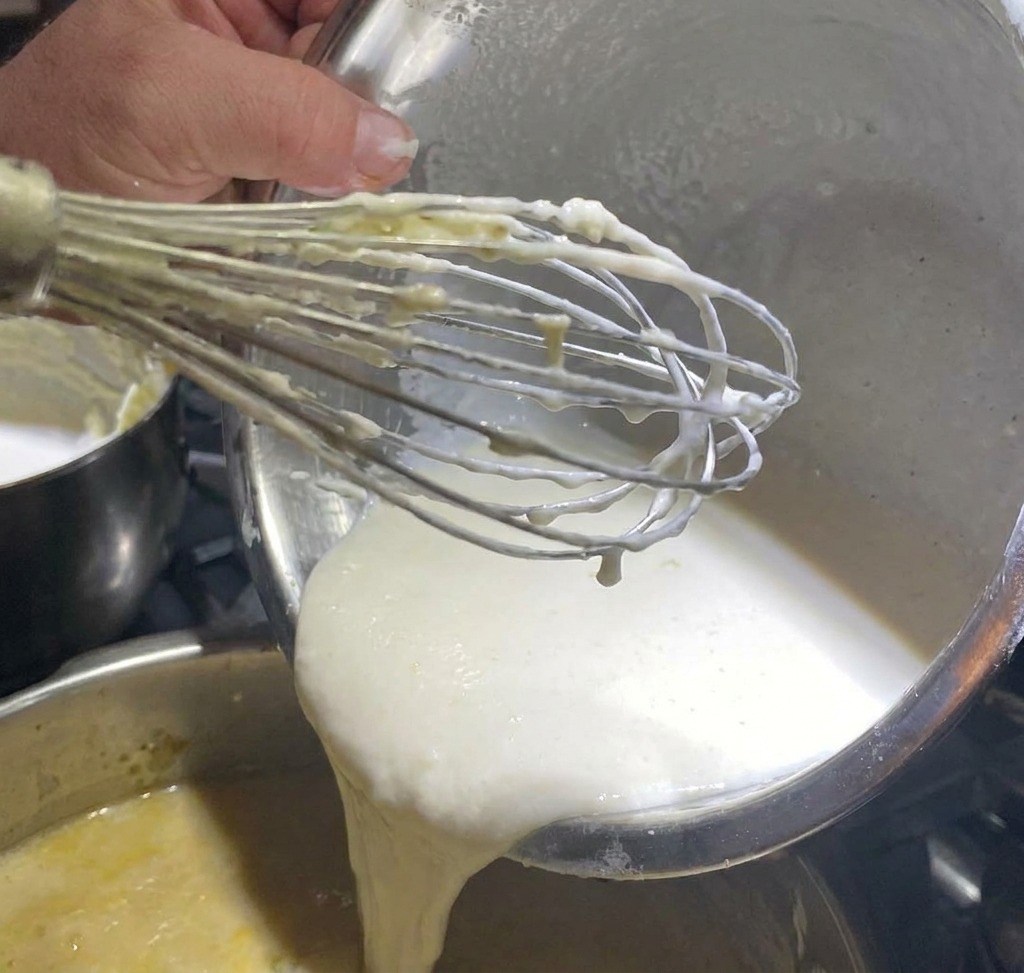 Poivre blanc saupoudré sur une base de chaudrée de palourdes en train de mijoter.