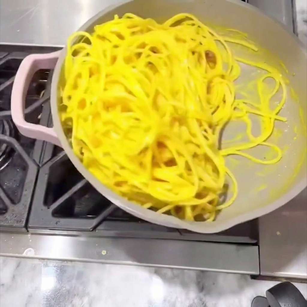 Spaghetti remués dans la poêle avec une sauce crémeuse jusquà enrobage total.