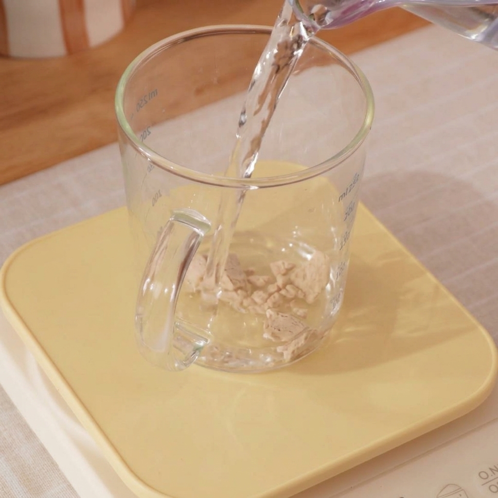 Gros plan sur un verre deau glacée et de levure en train dêtre mélangés.