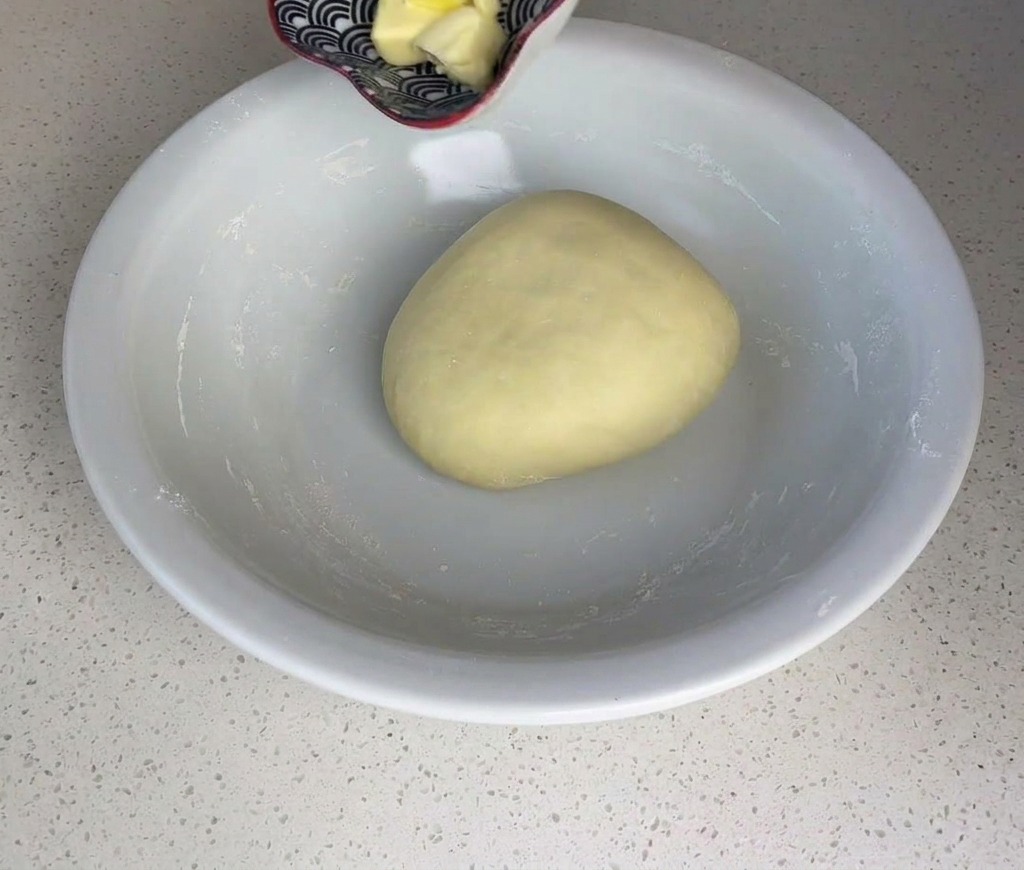 Cubes de beurre ajoutés à la boule de pâte.