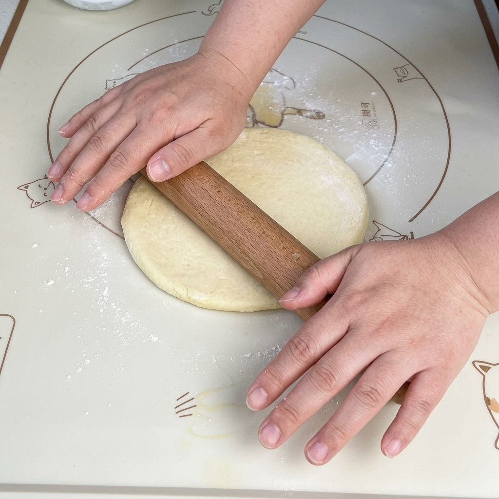 Rouleau à pâtisserie aplatissant la pâte en carré.
