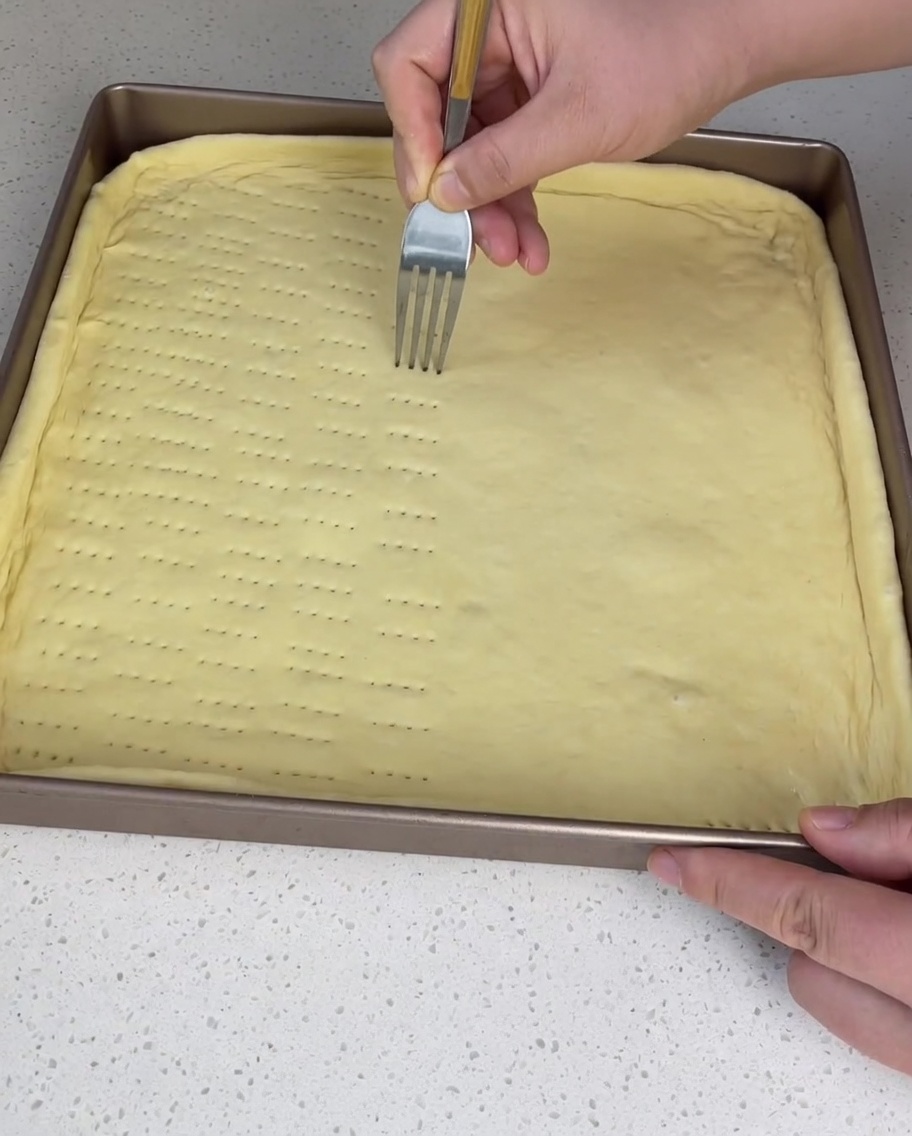 Fourchette piquant la pâte dans le moule.