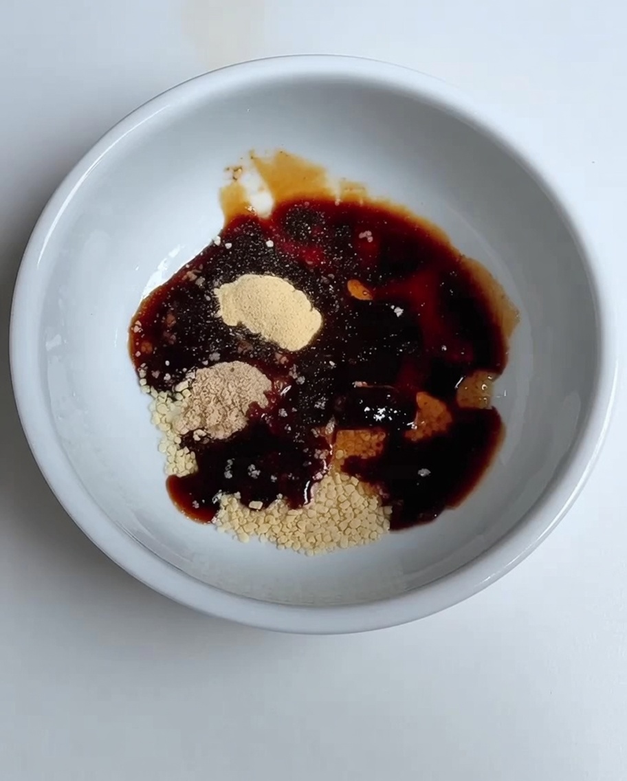 De leau est versée dans le bol contenant le mélange de sauce soja et dassaisonnements.