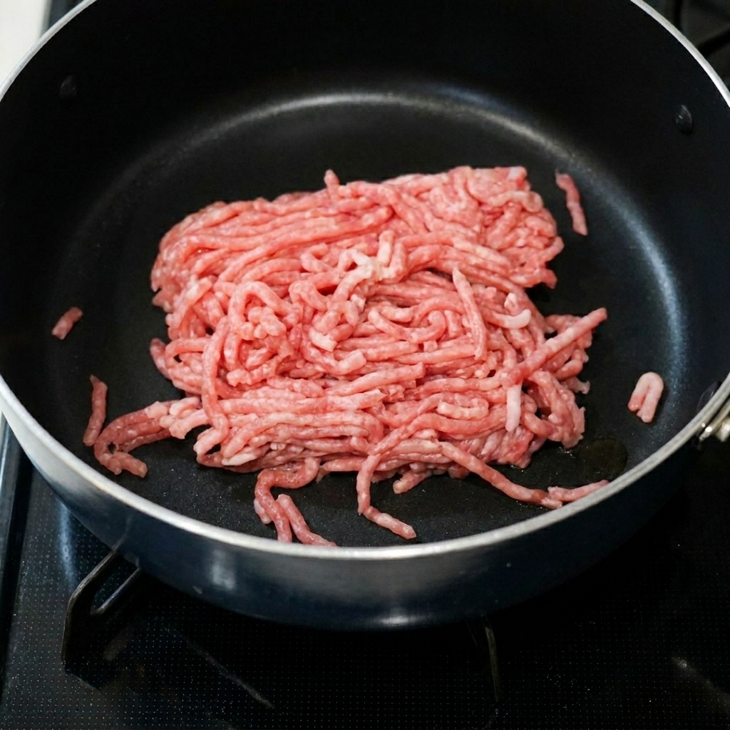 Porc haché grésillant dans une poêle avec de la pâte de haricots épicée et de la pâte dail.