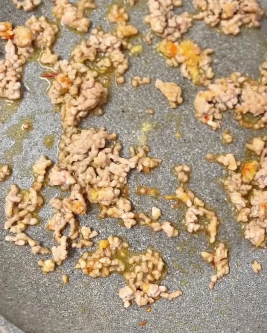 Assaisonnements comprenant du sésame moulu et du bouillon de poulet ajoutés dans la poêle.