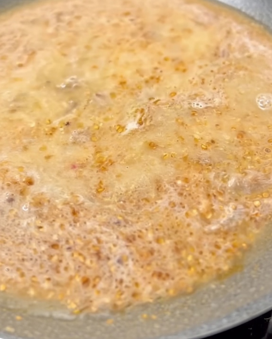 Lait incorporé au bouillon Tantanmen frémissant dans la poêle.