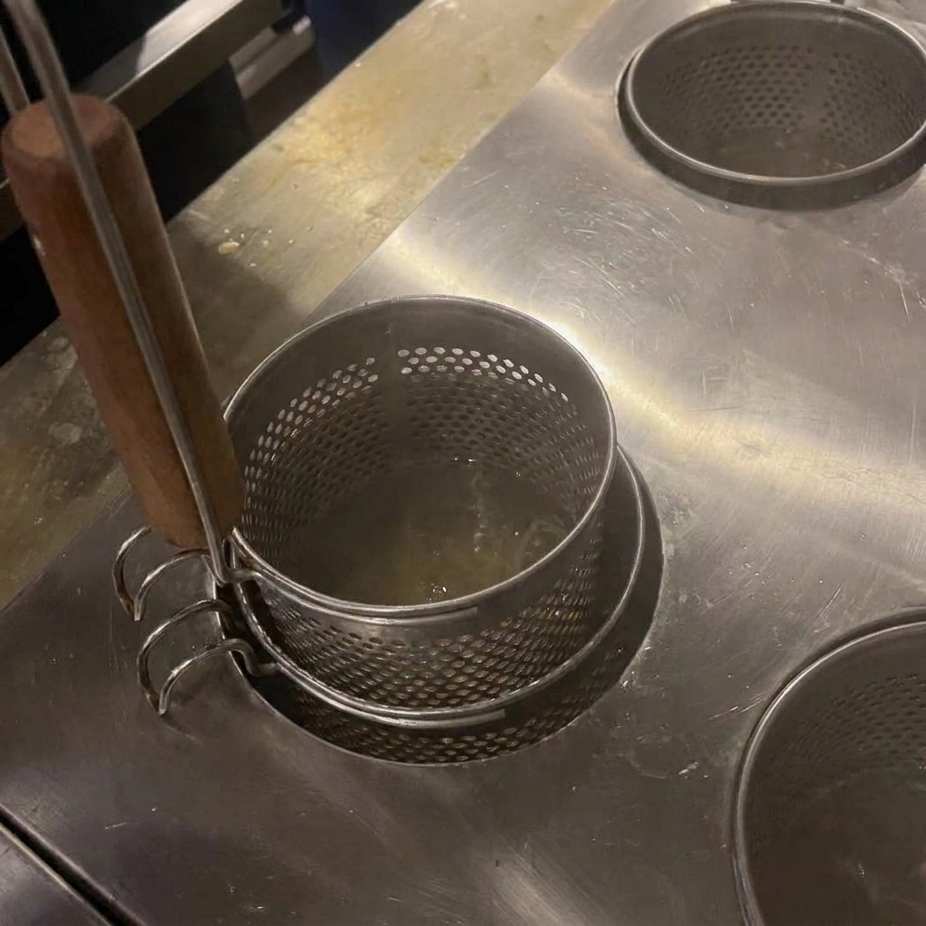 Nouilles remuées dans de leau bouillante avec des baguettes en bois.