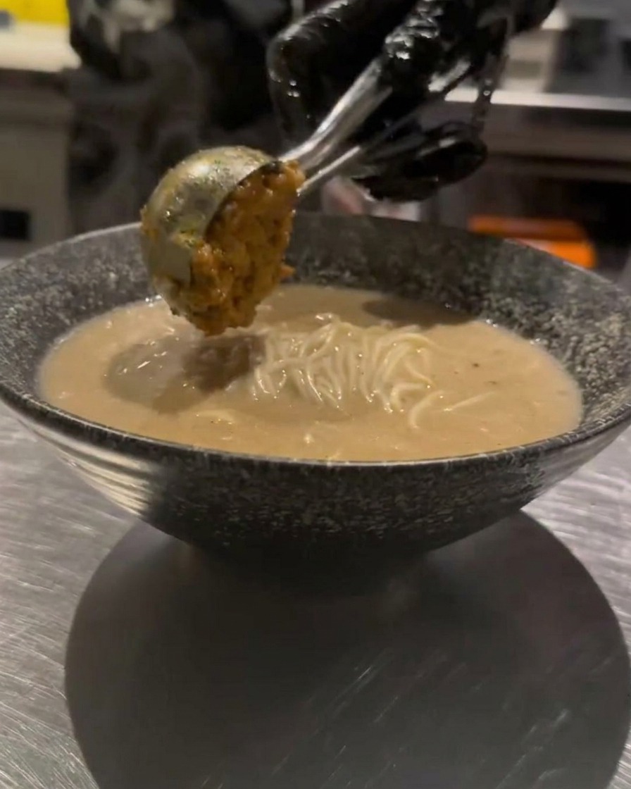 Une cuillerée de viande hachée assaisonnée soigneusement ajoutée sur les ramen.