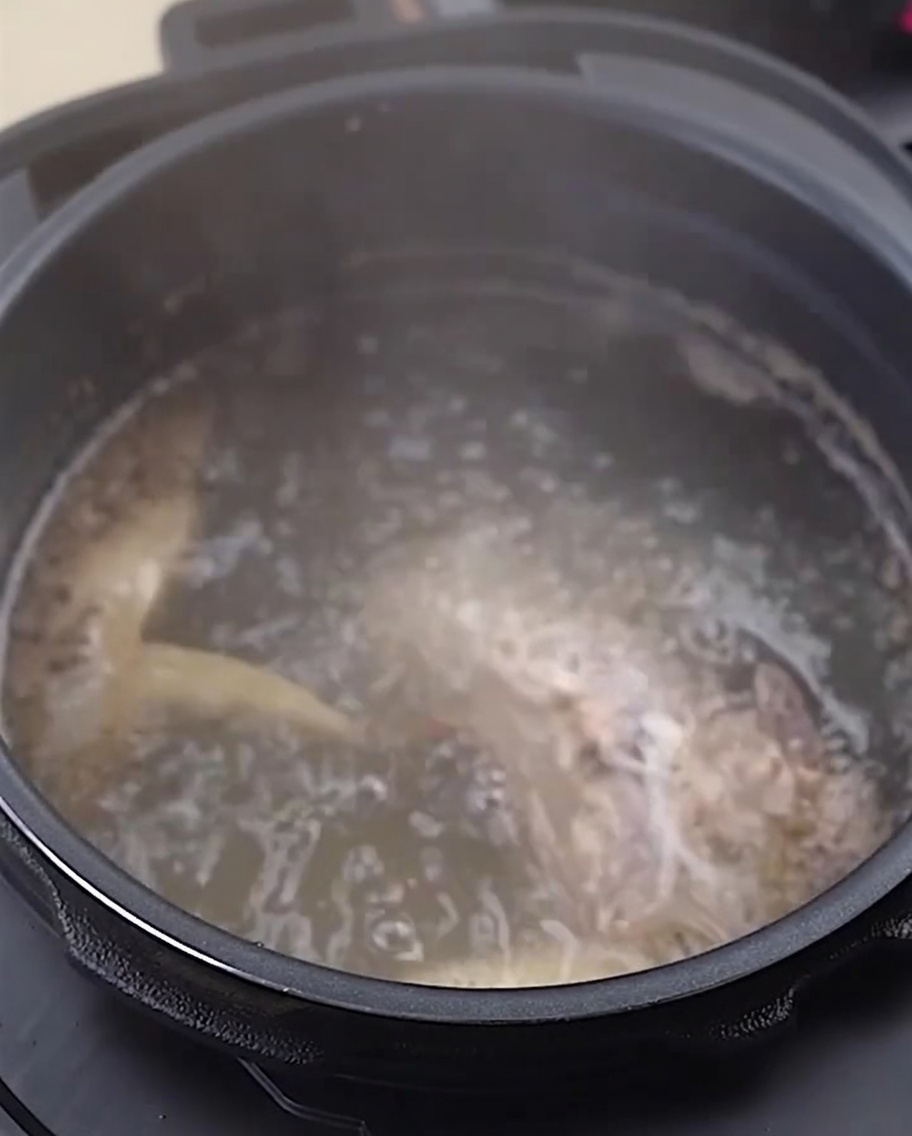 Os et pattes de poulet rincés dans un bol en acier inoxydable.