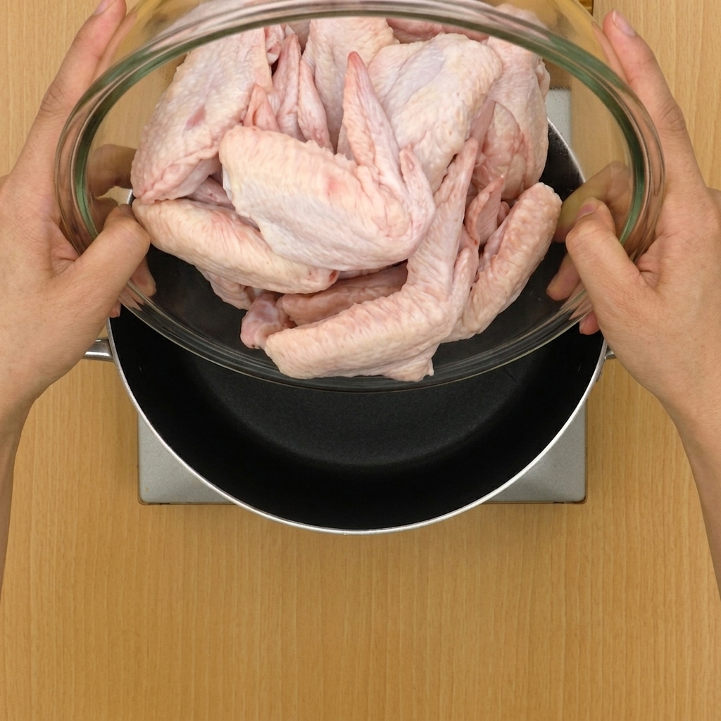 Ailes de poulet et aromates ajoutés dans une grande marmite remplie deau.