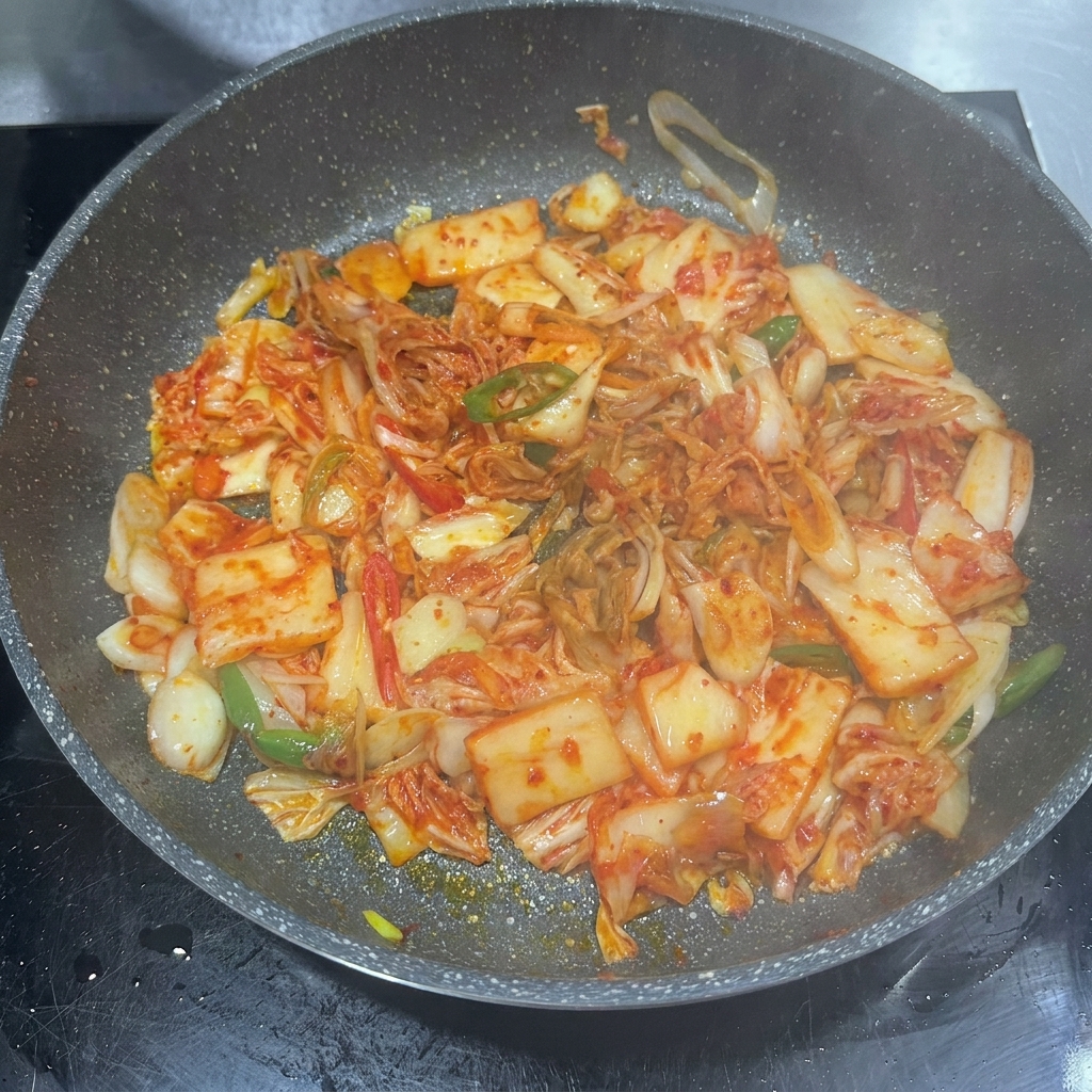 Pâte de piment, sauce soja et sucre ajoutés dans la poêle avec le kimchi.