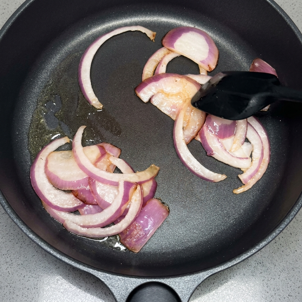 Tranches doignon rouge sautées à la spatule dans une poêle.
