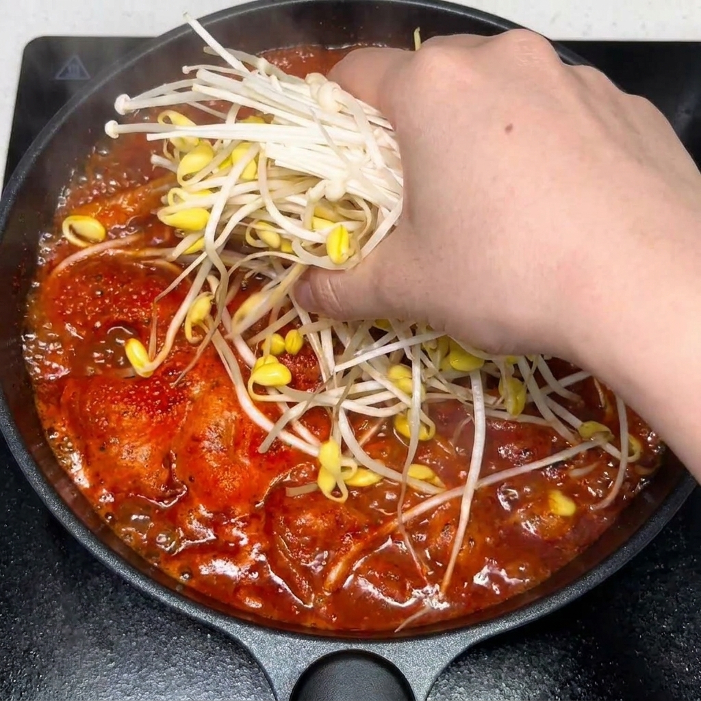 Ail émincé et assaisonnements incorporés dans la soupe épicée.