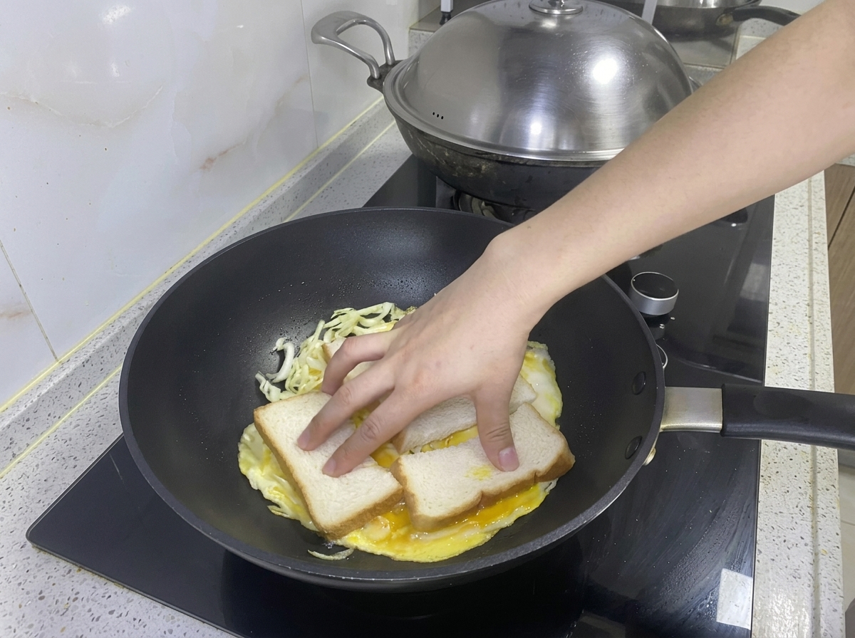 Deux tranches de pain placées sur lomelette chou-œuf dans la poêle.