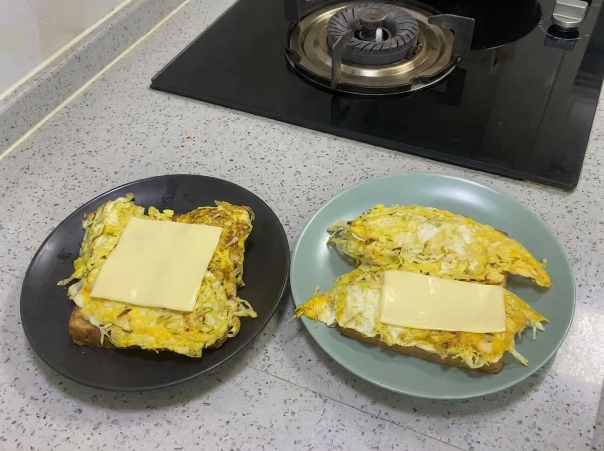 Tranche de fromage jaune fondant sur la couche dœuf et chou cuite.