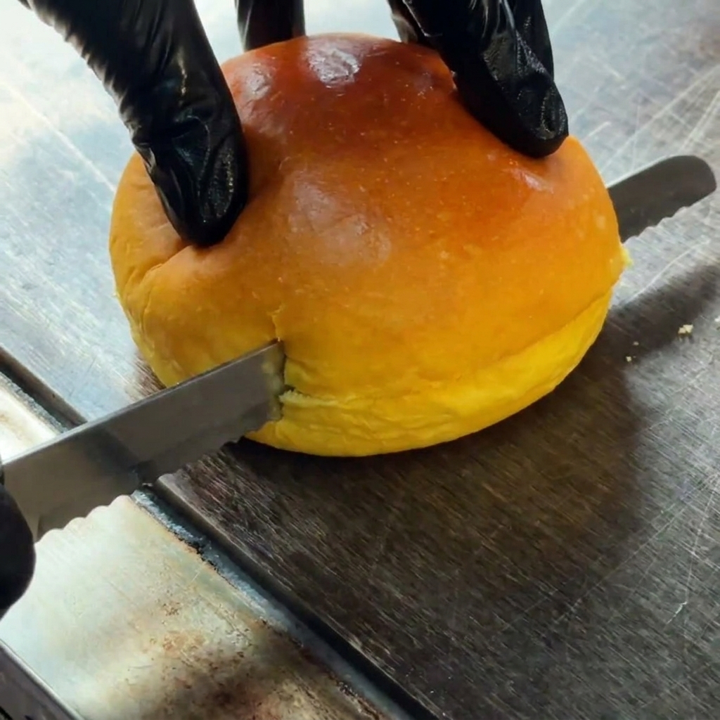 Un pain à burger coupé horizontalement en deux.