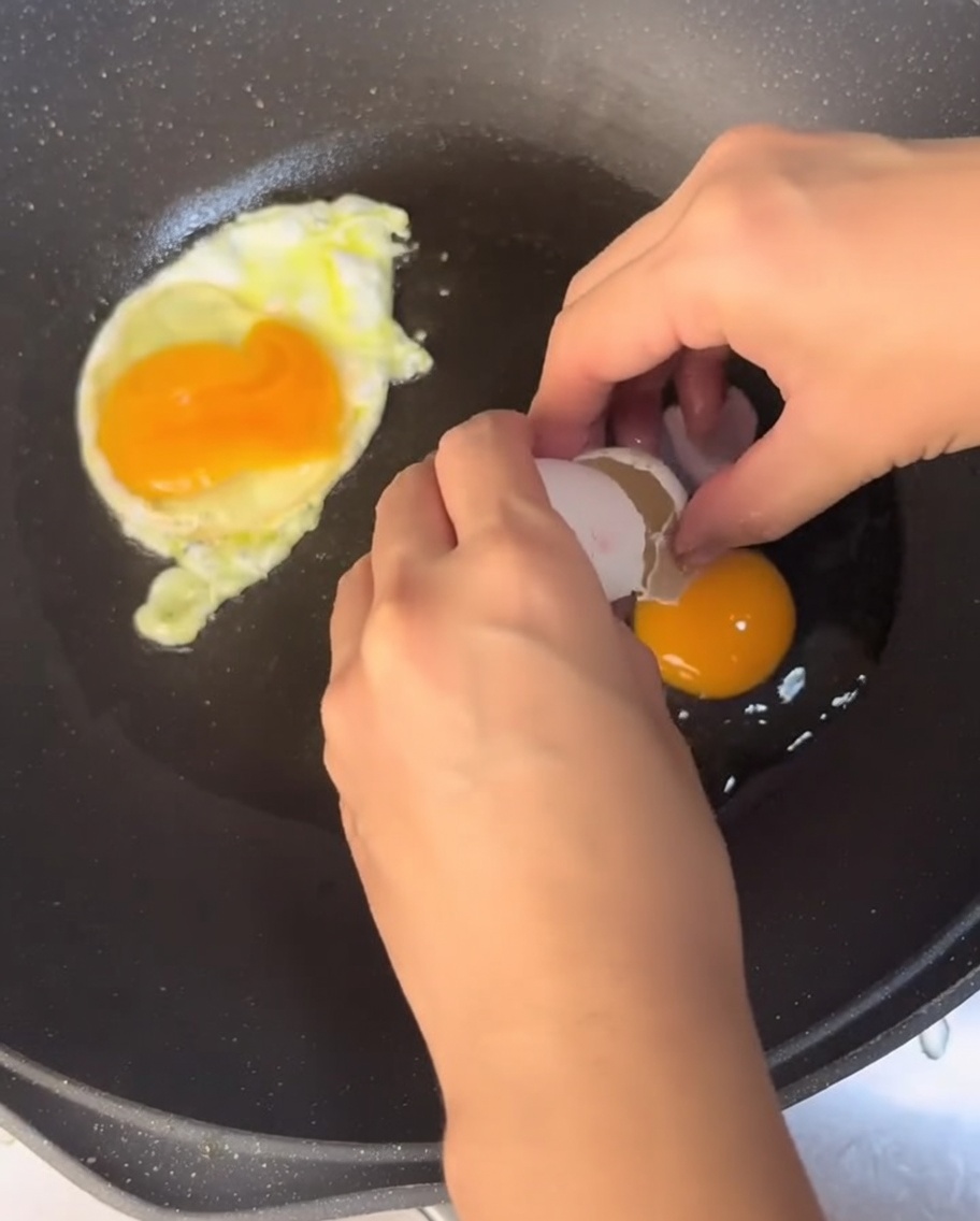 Œufs cuisant dans une poêle avec de lhuile chaude.