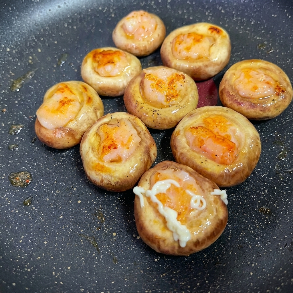 Gros plan dune sauce ajoutée sur la surface des champignons farcis aux crevettes.
