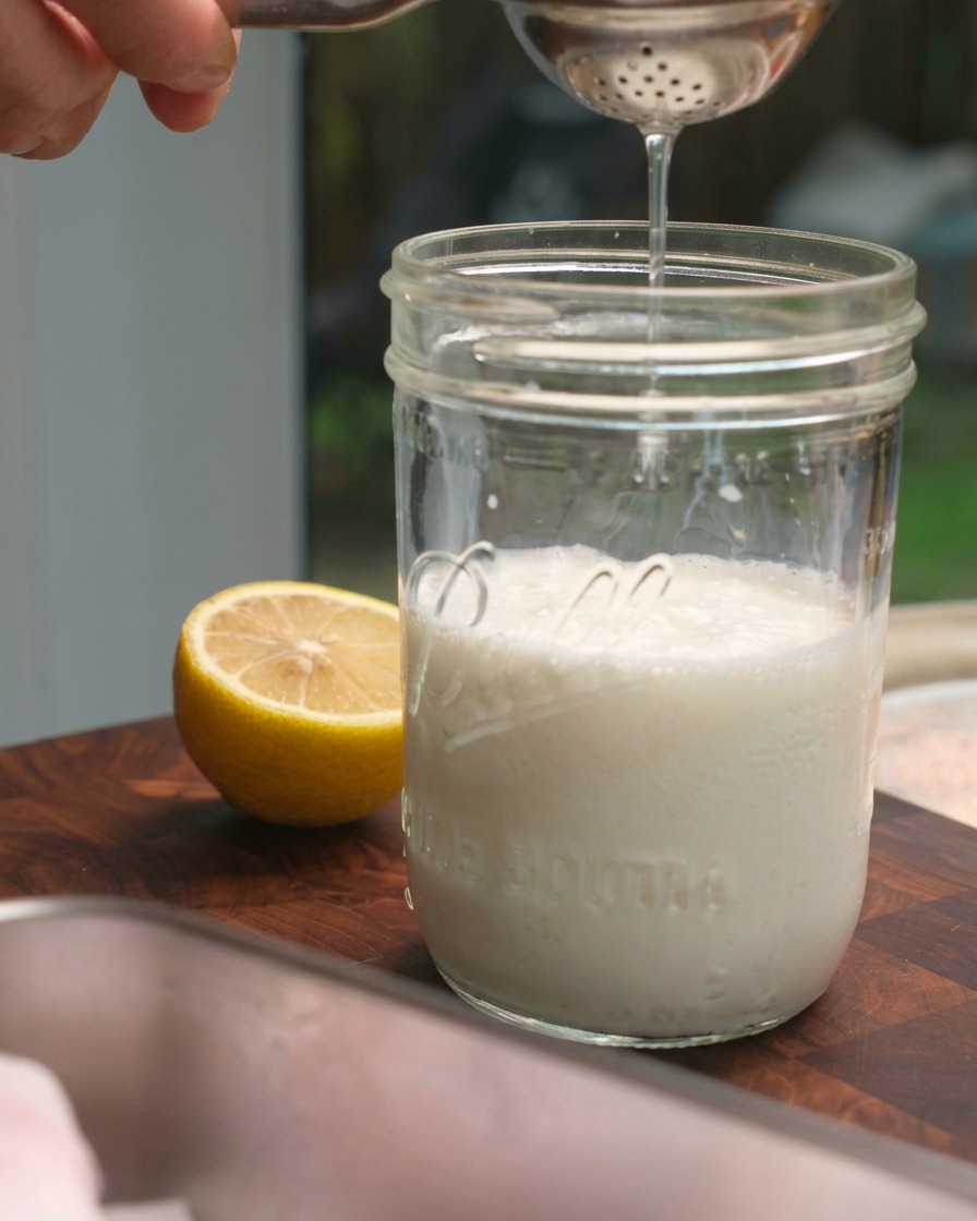 Jus de citron frais pressé dans un bocal en verre rempli de lait.