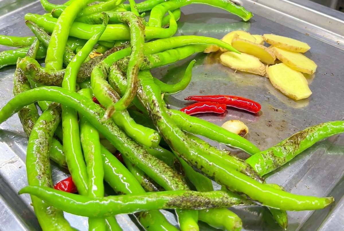 Tranches de gingembre saisies sur la plaque avec des piments.