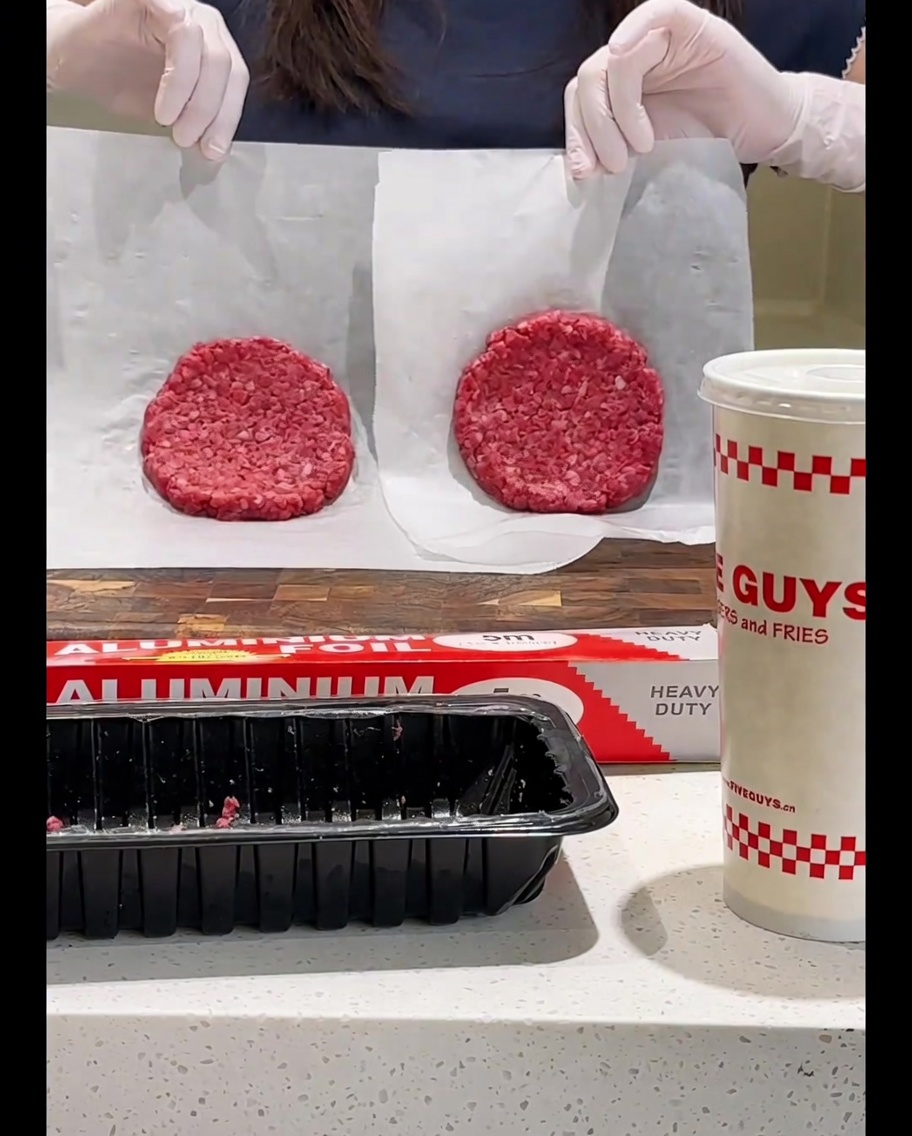 Retournement du steak de bœuf dans la poêle avec une spatule.