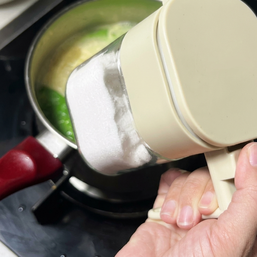 Du sel ajouté à la soupe depuis un récipient dassaisonnement en plastique transparent.