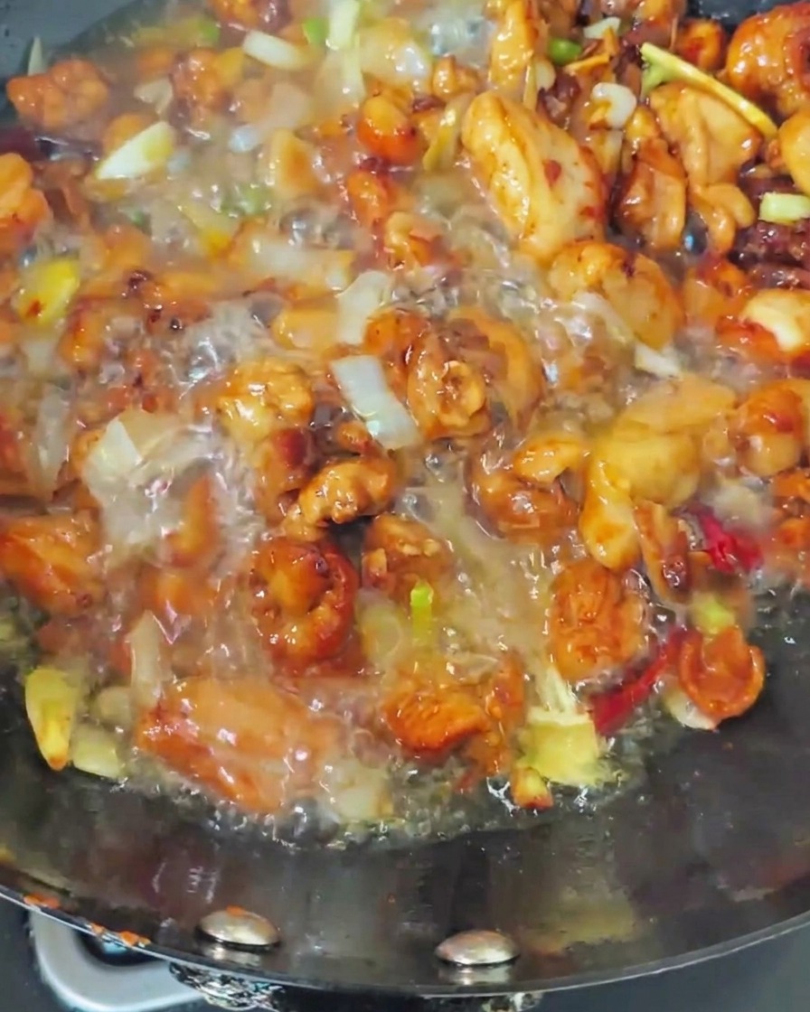 Eau bouillante versée dans le wok sur le poulet.