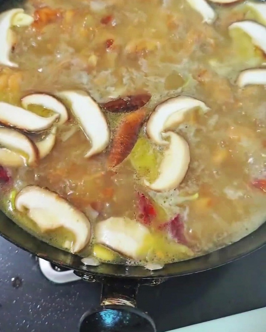 Champignons shiitake mijotant dans le bouillon de poulet.