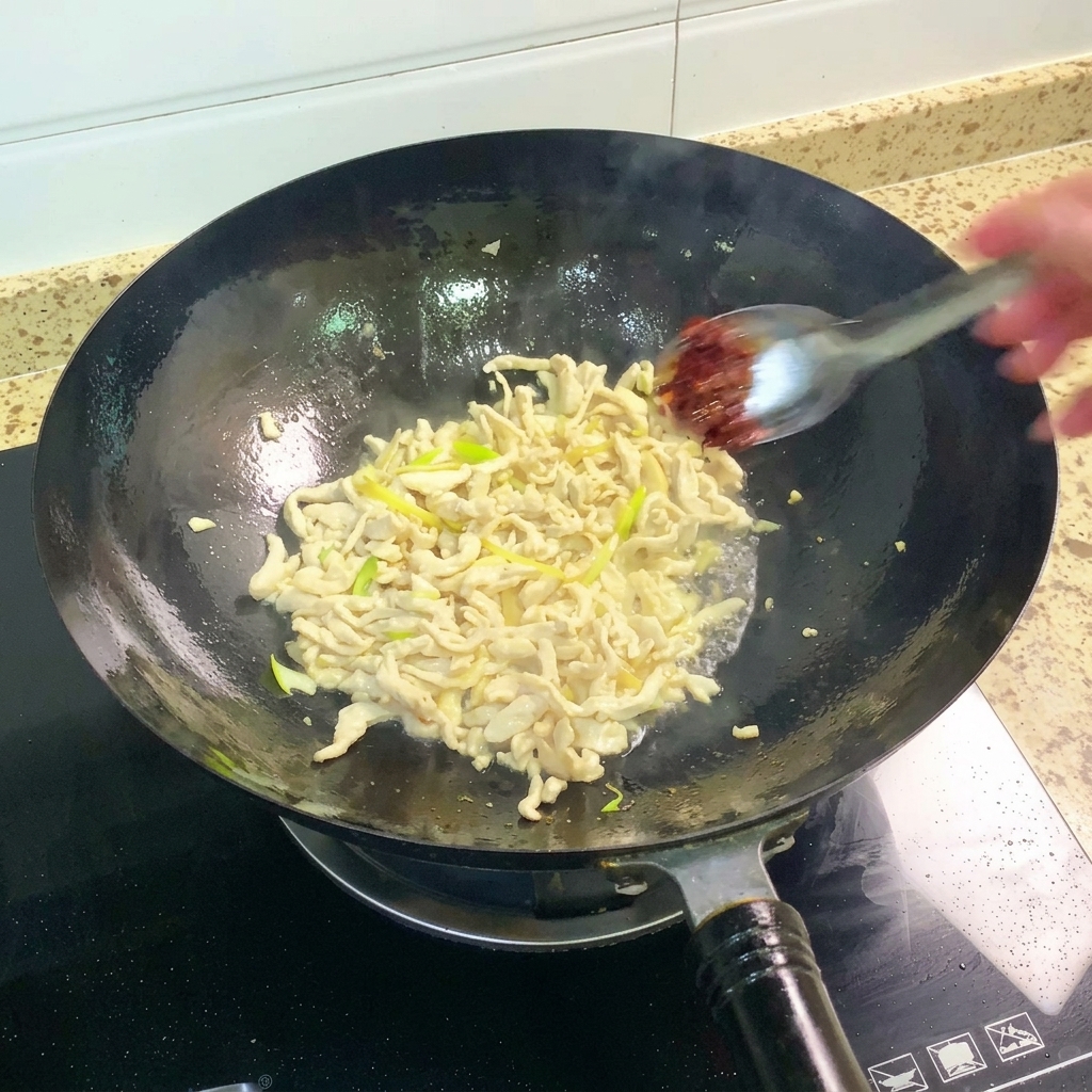 Pâte de haricots Pixian ajoutée au wok et mélangée au poulet.