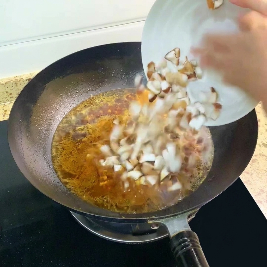 Champignons shiitake en dés ajoutés au bouillon bouillonnant dans le wok.