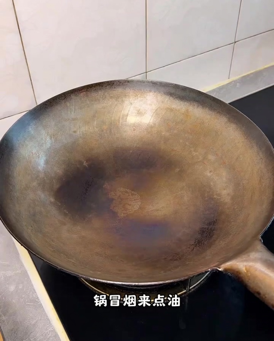 Un wok bien chaud sur une cuisinière avec de la fumée visible.