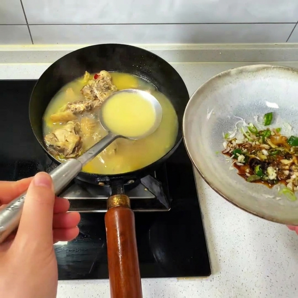 Verser une louche de bouillon de poulet chaud dun wok dans un bol dassaisonnements.