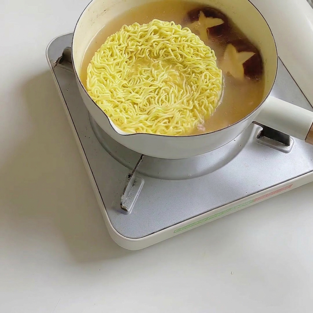 Feuilles de bok choy frais ajoutées dans la casserole de ramen.