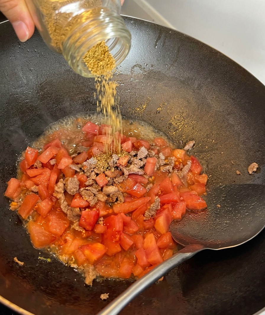 Sel de mer saupoudré sur un mélange de bœuf sauté et de tomates en dés.