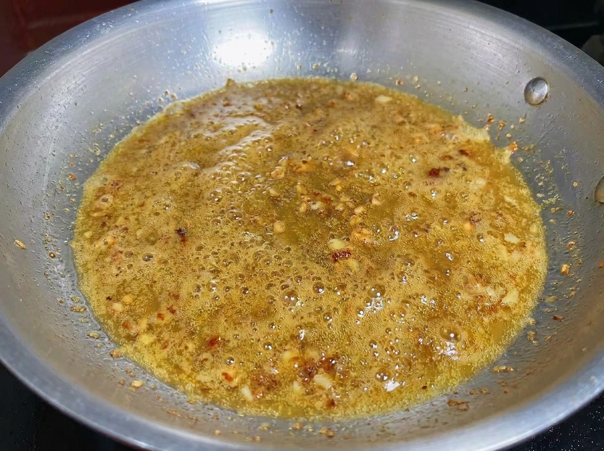 Ail haché et crevettes cuisant ensemble dans une huile infusée.