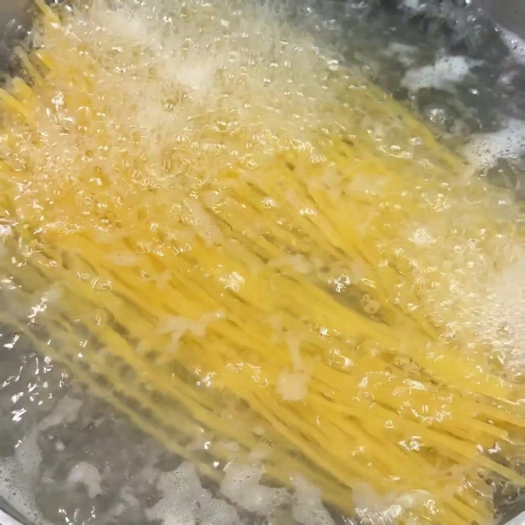 Spaghettis en train de cuire dans une casserole deau bouillante bouillonnante.
