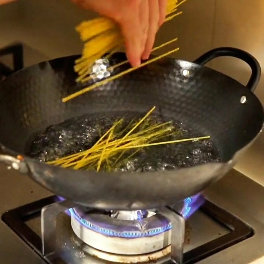 Des nouilles de maïs plongées dans une casserole deau bouillante.