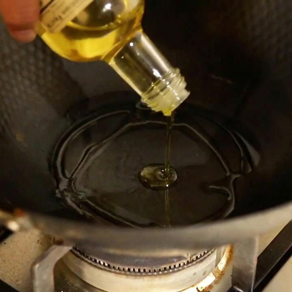 De lail et du piment émincés crépitant dans une poêle avec de lhuile dolive chaude.