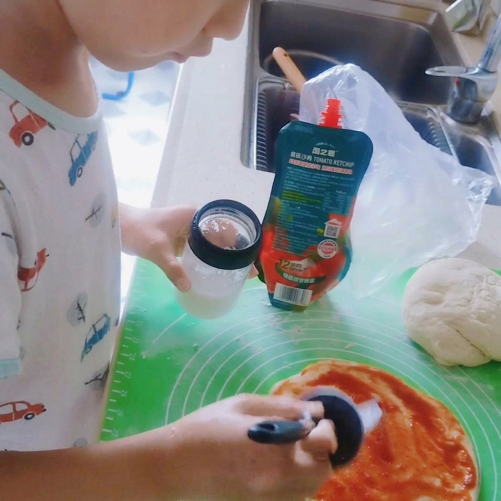 Sel saupoudré sur la sauce tomate de la pizza.