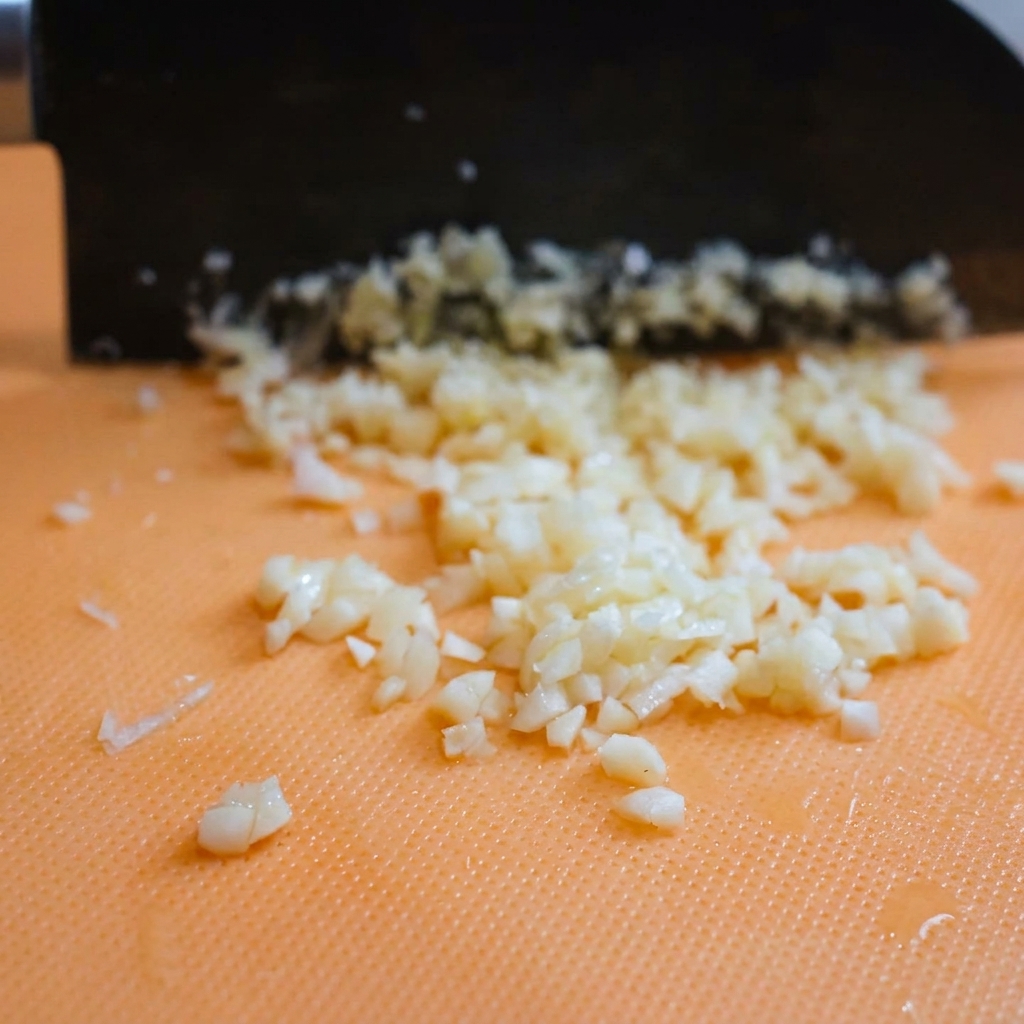 Tas de fromage parmesan fraîchement râpé reposant sur une planche à découper après avoir été préparé.
