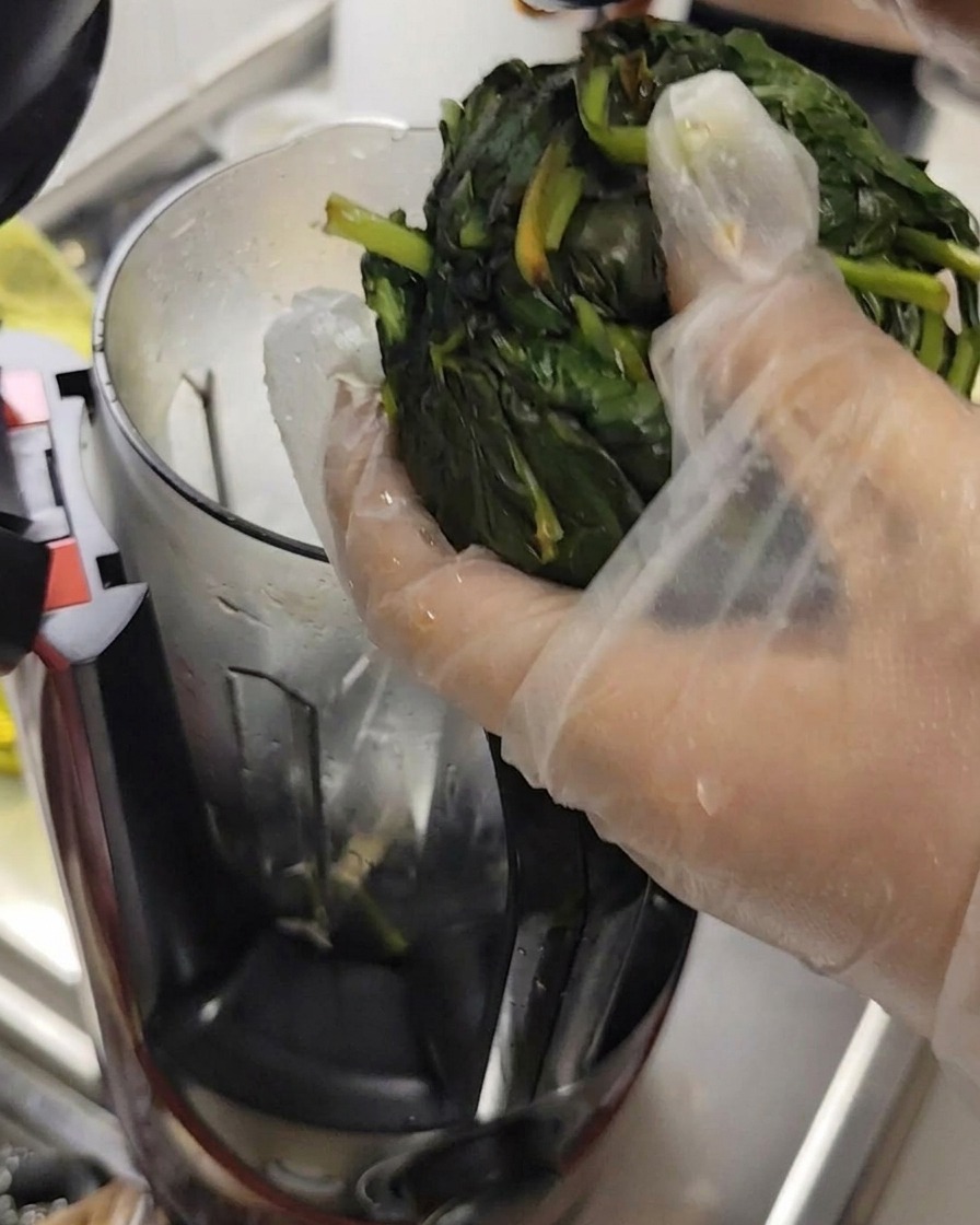 Essorage de feuilles de basilic à mains gantées pour retirer leau, préparation pour le robot culinaire.