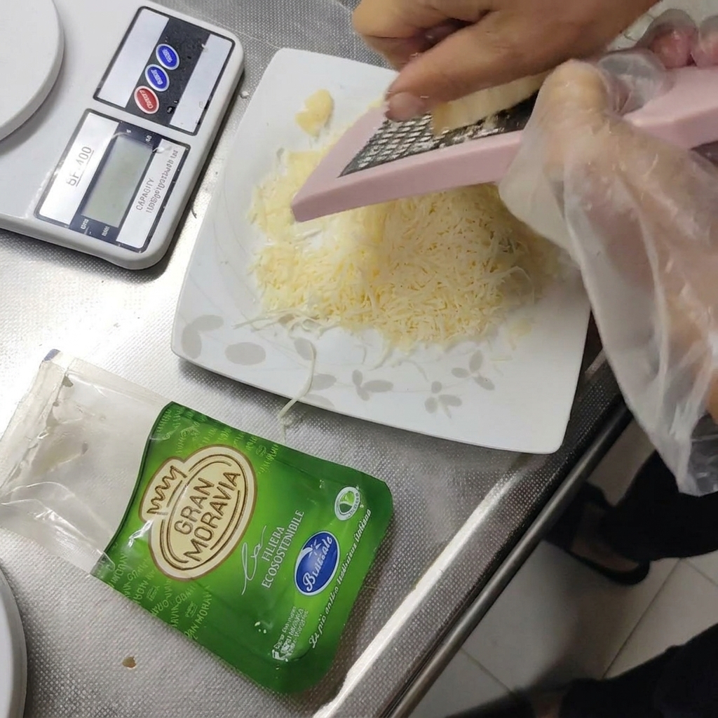 Fromage à pâte dure Gran Moravia râpé sur une petite assiette.
