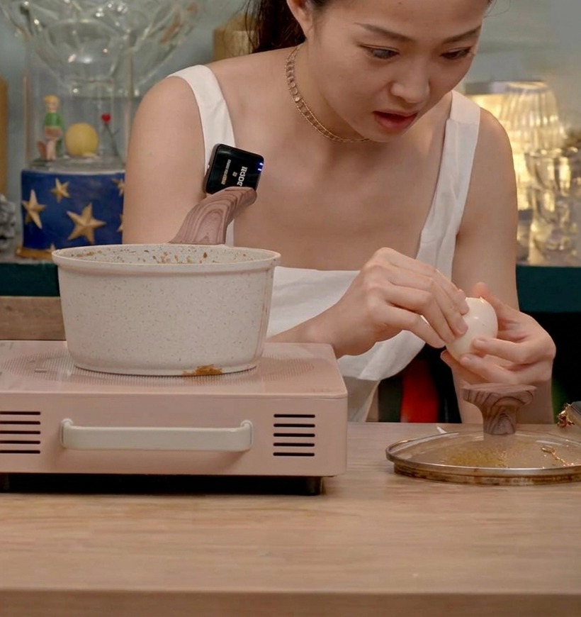 Œufs mollets écalés ajoutés dans une marmite avec le porc Chashu braisé dans une sauce soja sombre.