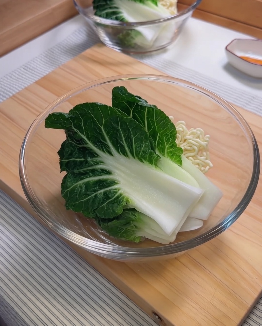 Ingrédients pour la sauce sésame, dont la pâte de sésame et lhuile pimentée, mélangés dans un bol en verre.