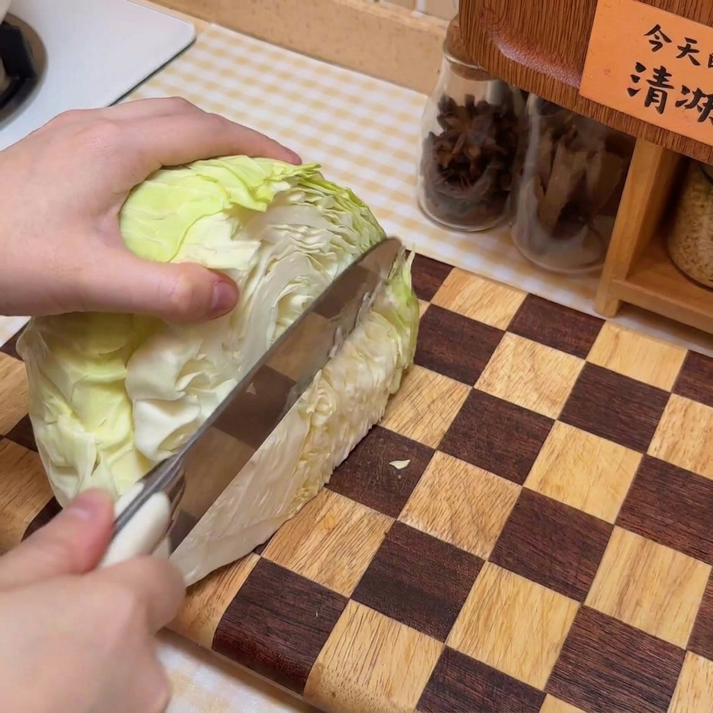 Un chou en train dêtre émincé sur une planche à découper en bois à carreaux.