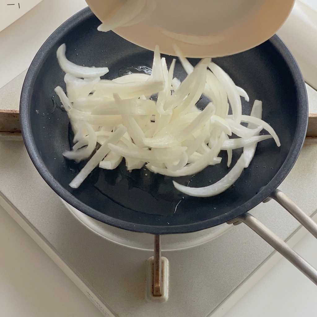 Oignons qui ramollissent dans une poêle avec de lhuile chaude.
