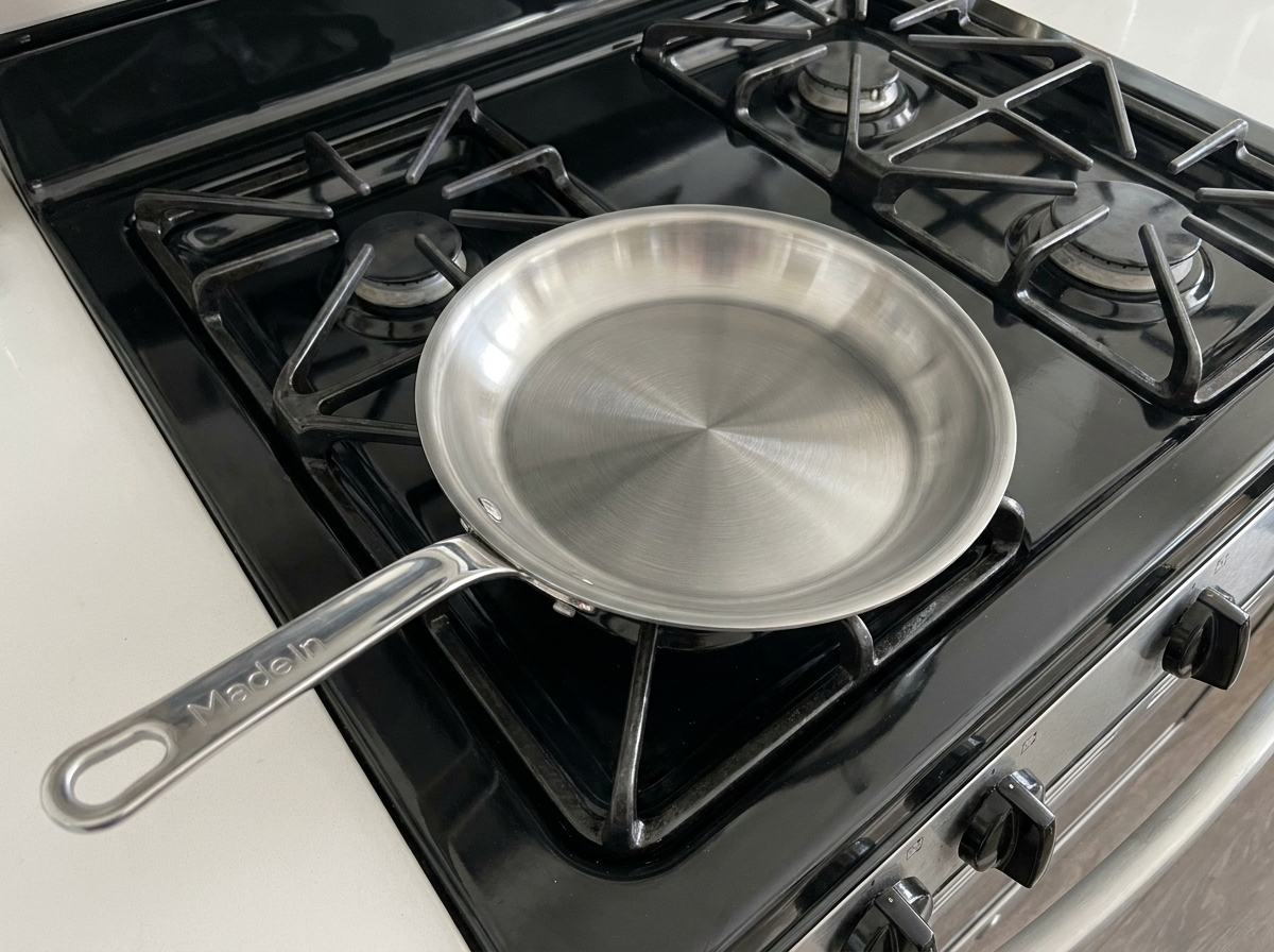 Une écumoire récupérant des miettes de pâte croustillantes à la surface de lhuile de friture.