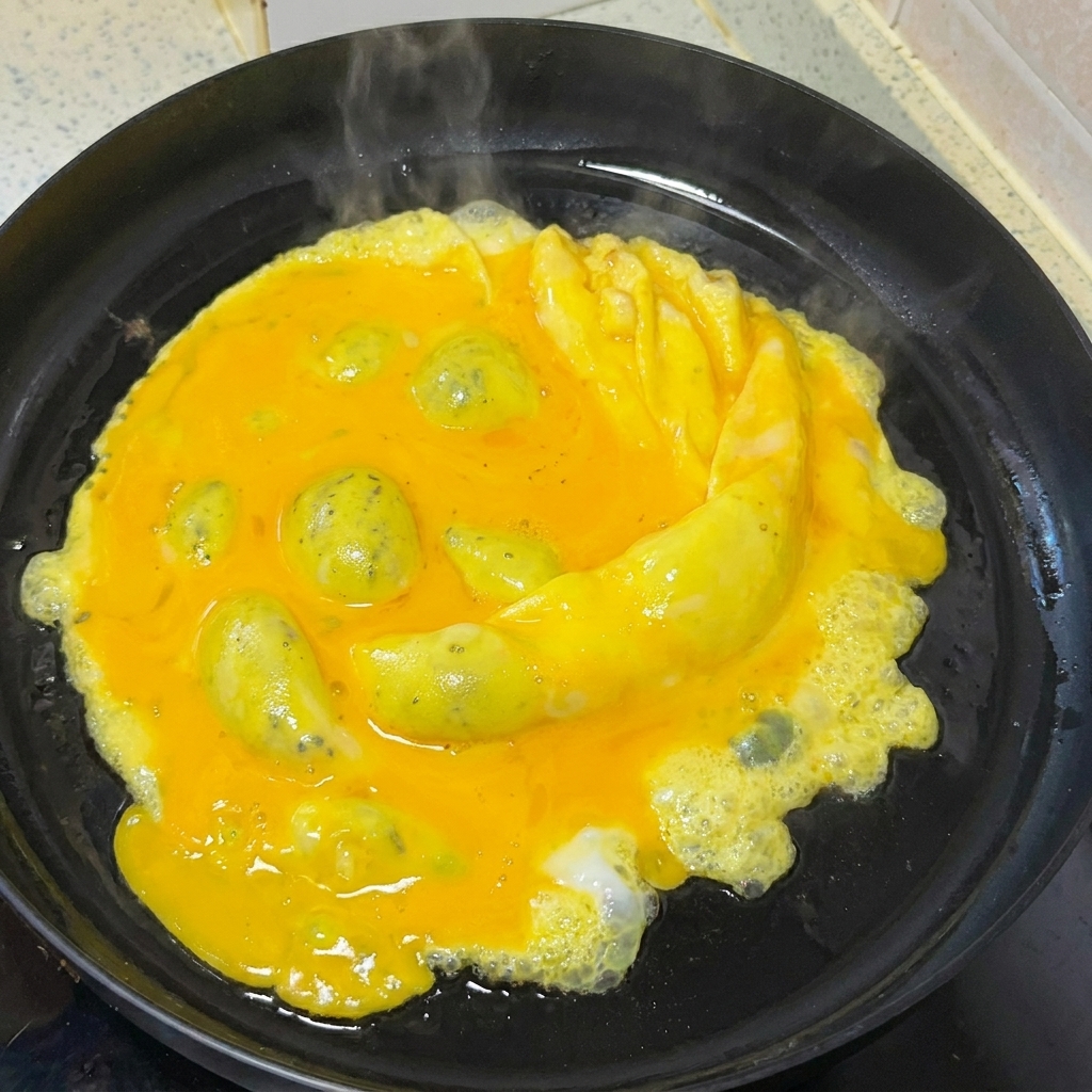 Des œufs doucement brouillés dans une poêle avec une spatule en bois.