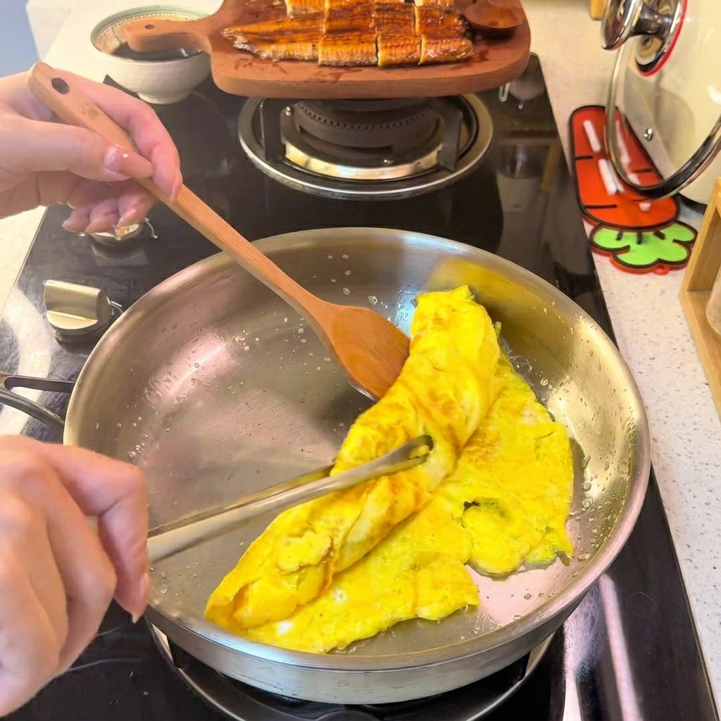 Une omelette roulée étant découpée en fines lamelles uniformes sur une assiette blanche.